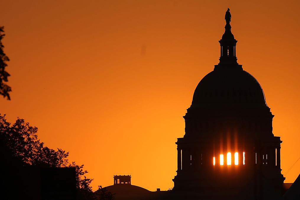 The early morning sun rises behind the U.S. Capitol building Sep