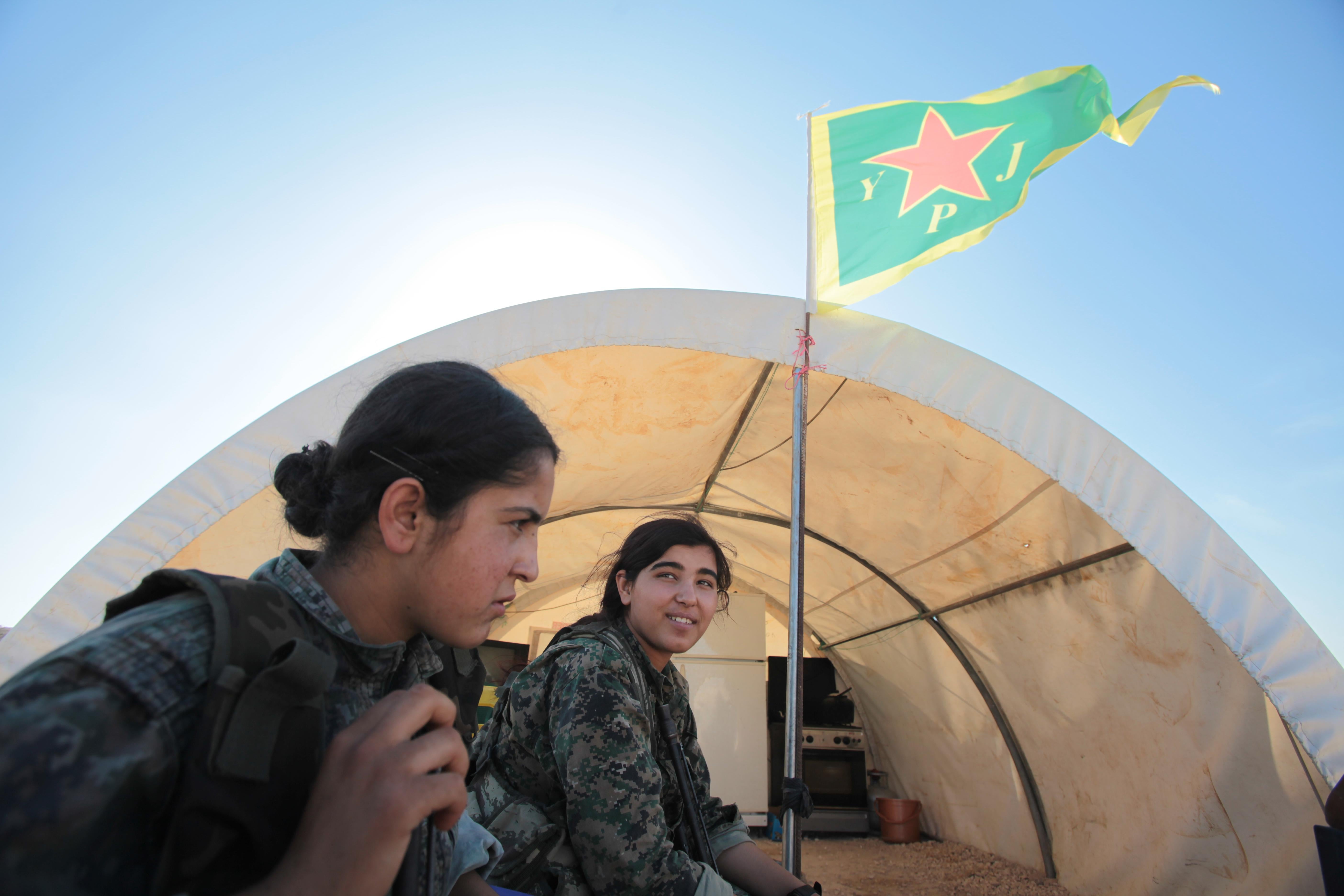 A Kurdish People's Protection Unit rests a base camp at the outskirts of the destroyed Syrian town of Kobane in 2015. 