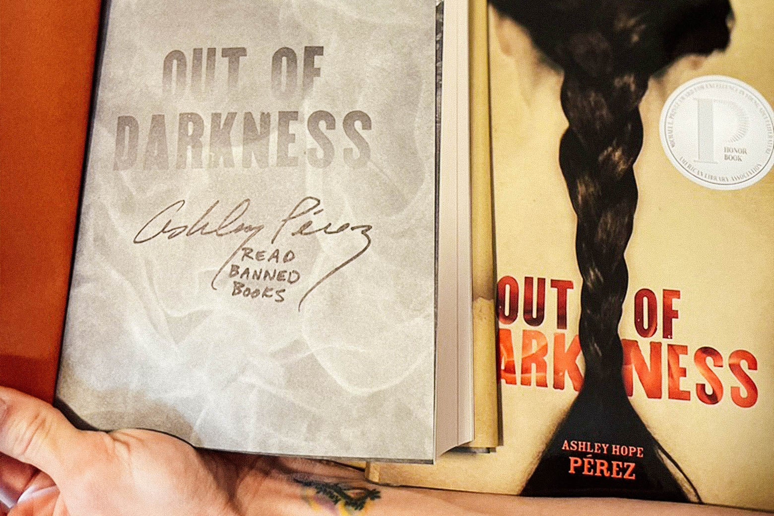 A signed copy of the book Out of Darkness with text that says, "Read banned books."