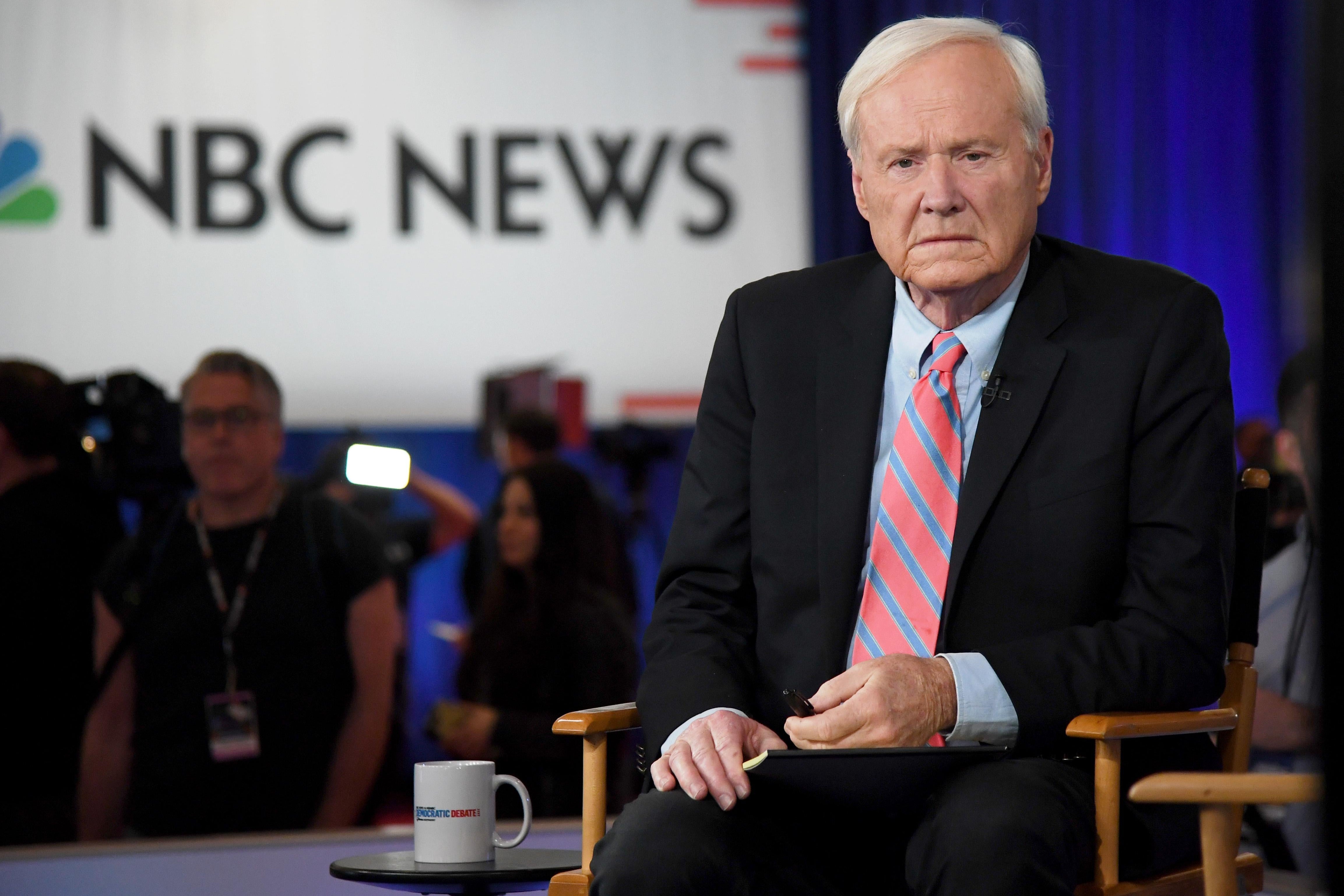 Chris Matthews seated in front of a screen displaying the NBC News logo.