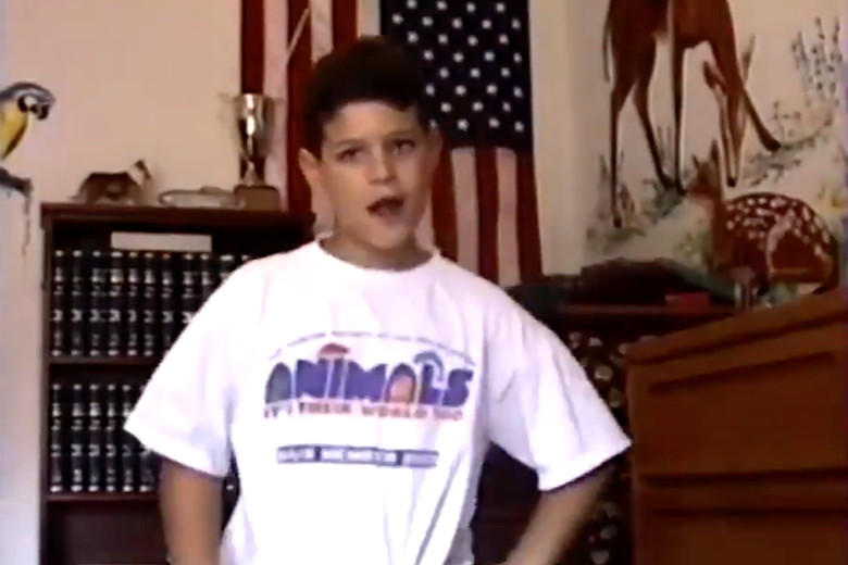The author, as a 9-year-old boy, dancing in a large white T-shirt with his hands on his hips and his head slightly tilted. An American flag is on the wall in the background.