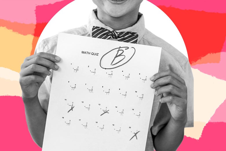 A child holds up a graded test with a "B" grade.