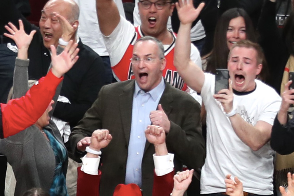 A fan in a suit behind Lillard stares with his eyes wide open in disbelief.