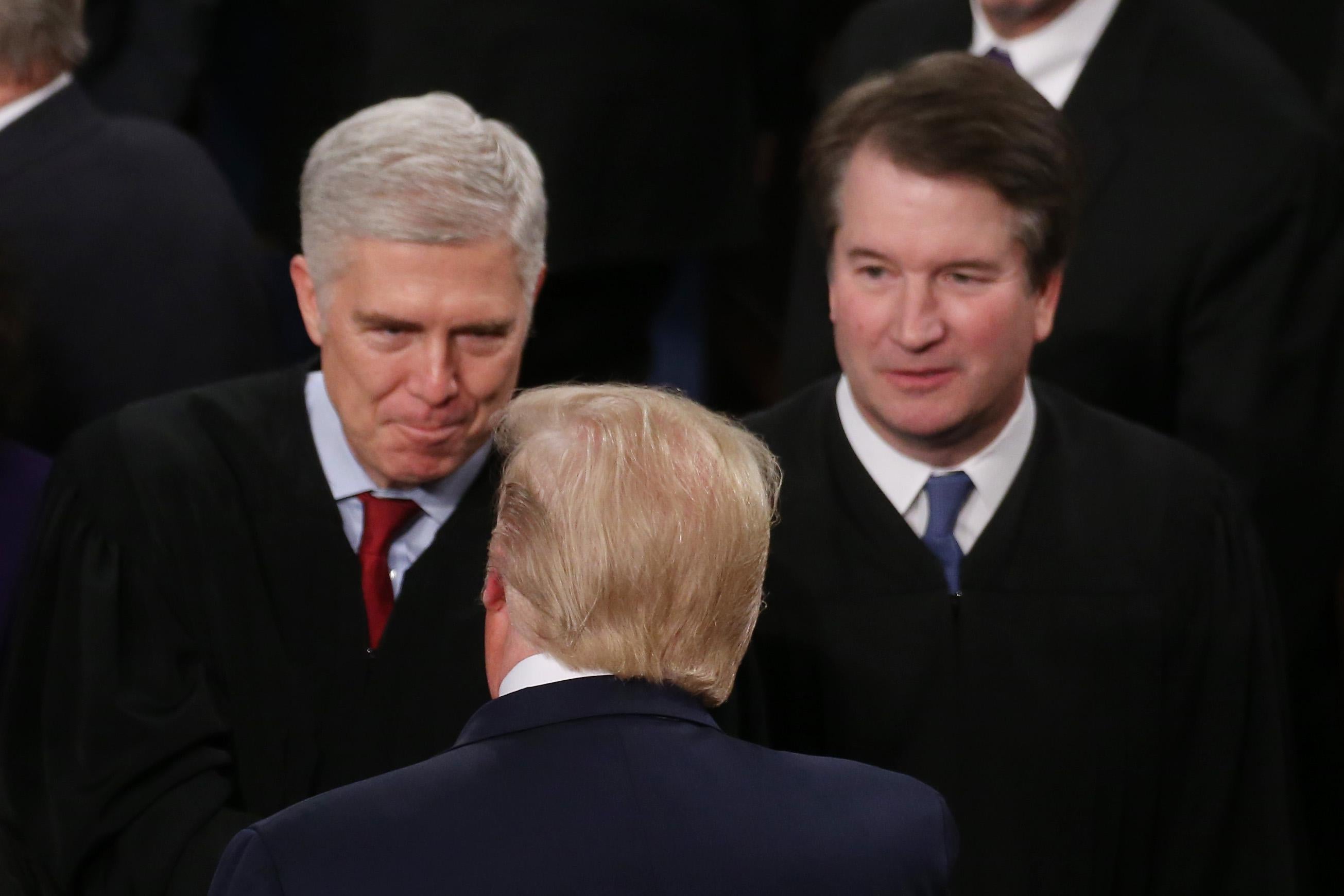 Trump, seen from behind, greets Gorsuch as Kavanaugh looks on