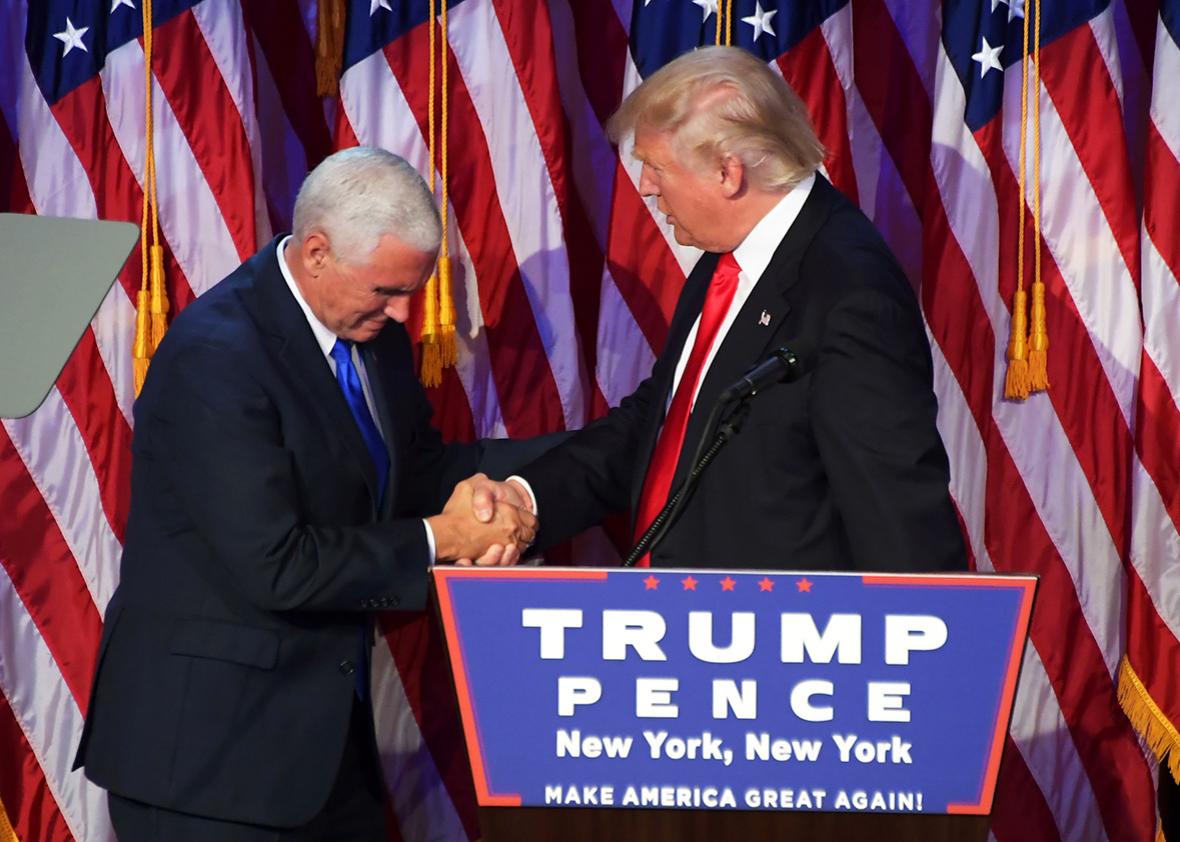 Republican presidential elect Donald Trump shakes hands with Republican candidate for Vice President Mike Pence speak during election night at the New York Hilton Midtown in New York on November 9, 2016. 