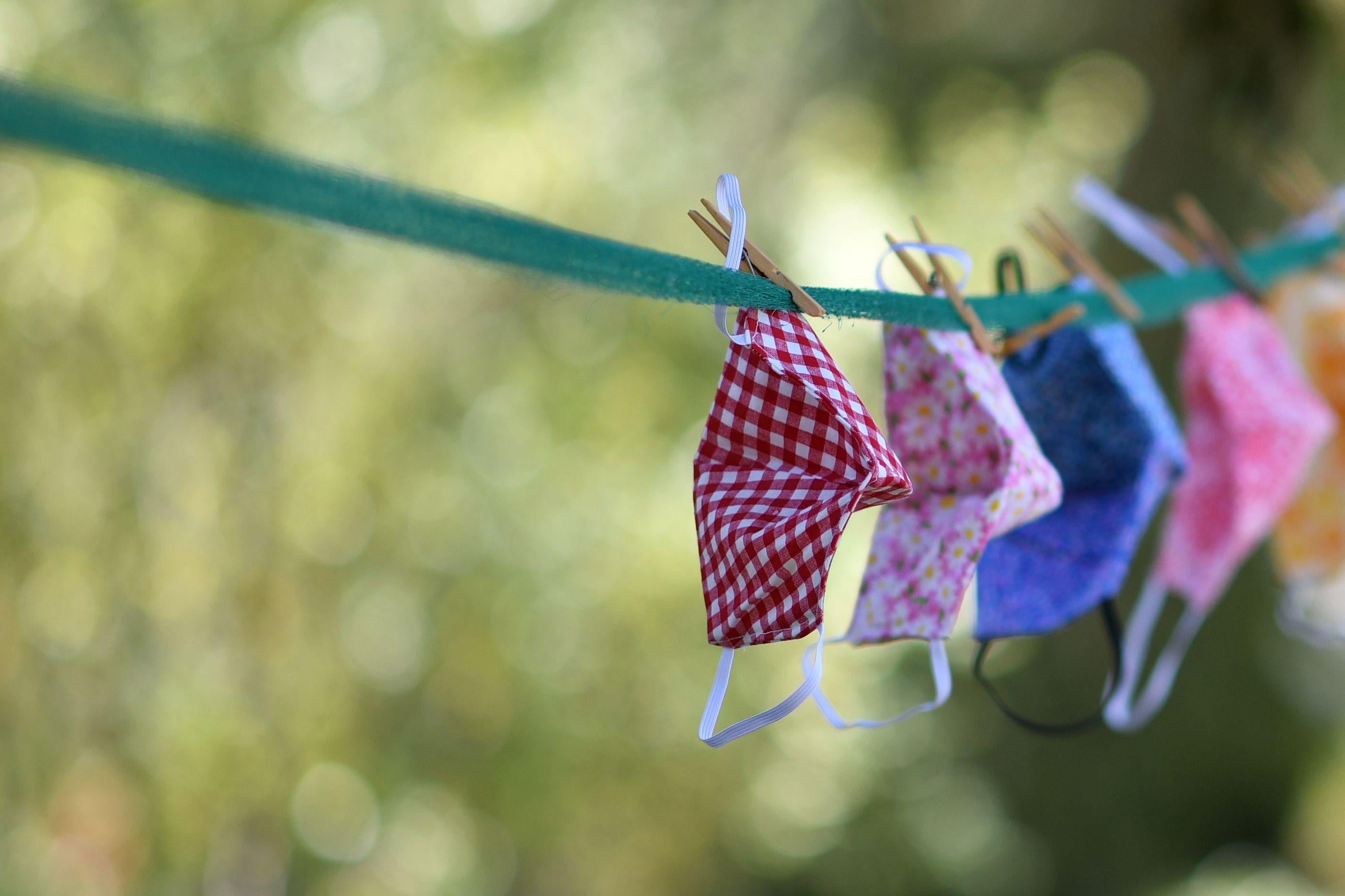 Masks hang on an outdoor clothesline.