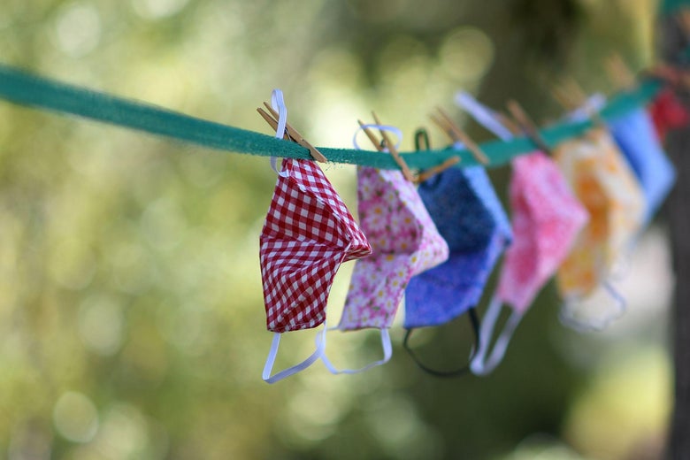 Masks hang on an outdoor clothesline.