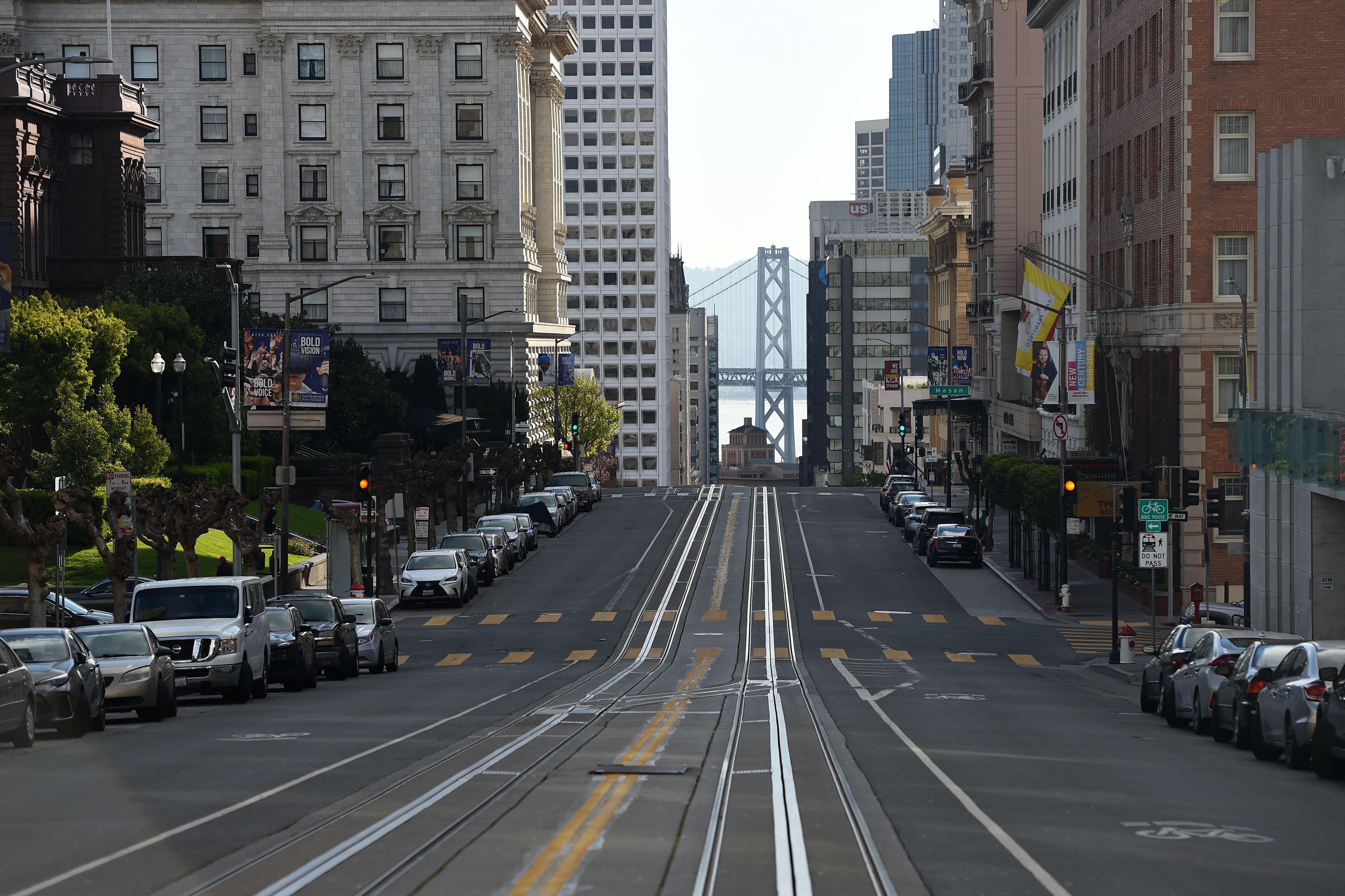 An empty street. The Golden Gate Bridge can be seen in the distance.
