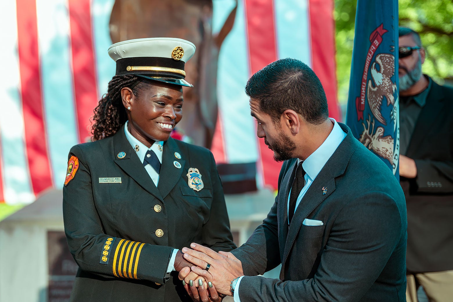 Abdul El-Sayed shakes hands with a woman in a military uniform.