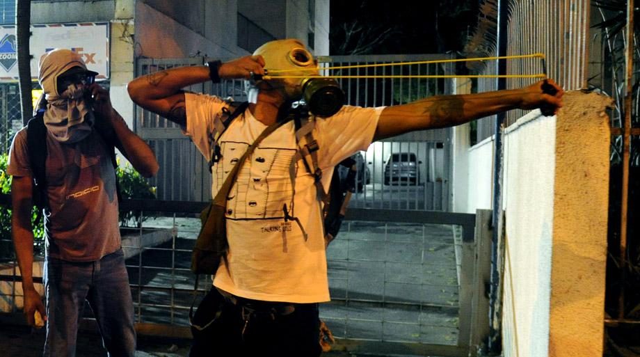 Protesters confront riot policemen during an anti-government demo, in Caracas on February 19, 2014.