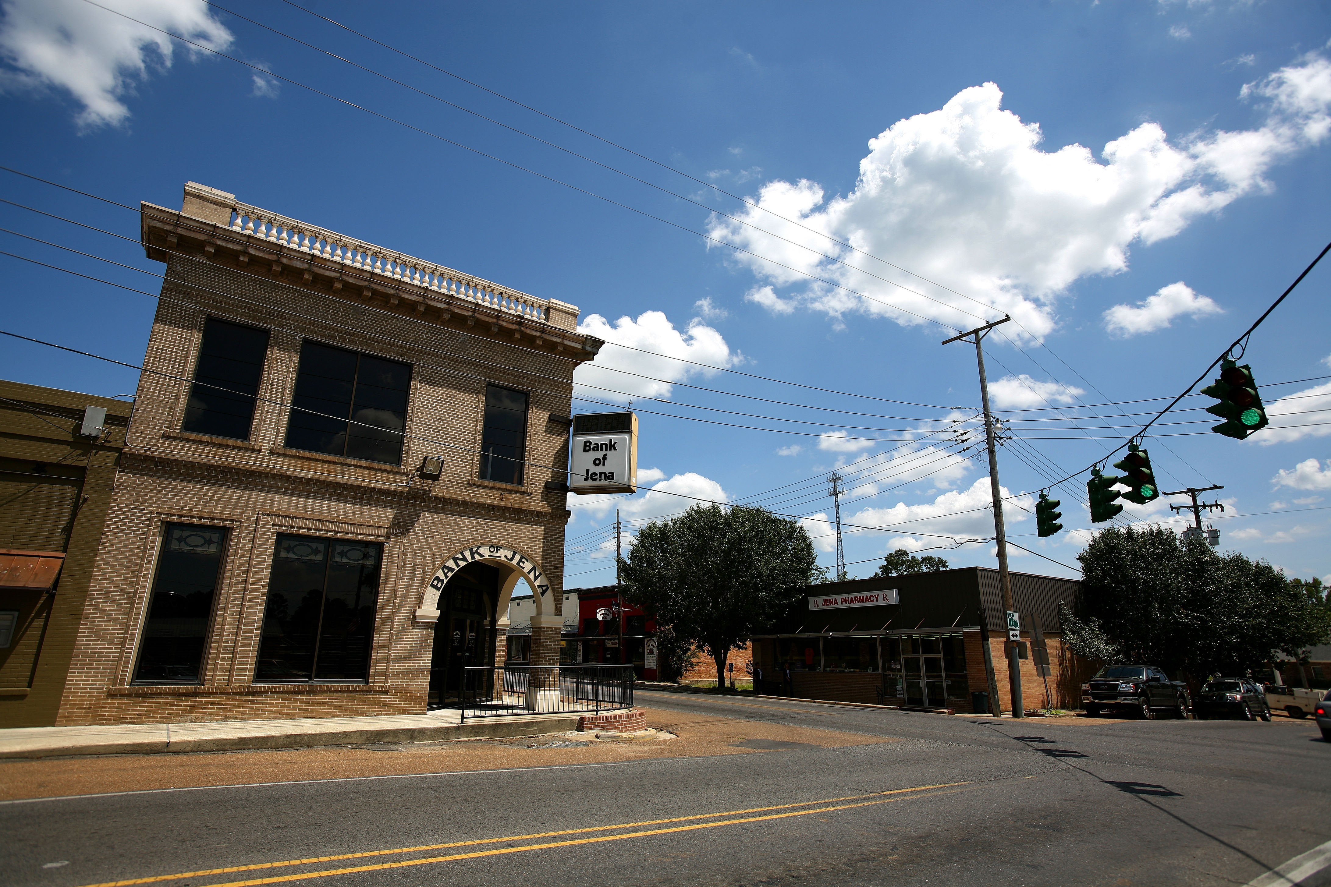 A brown-brick building on a corner street with a sign that reads "Bank of Jena."