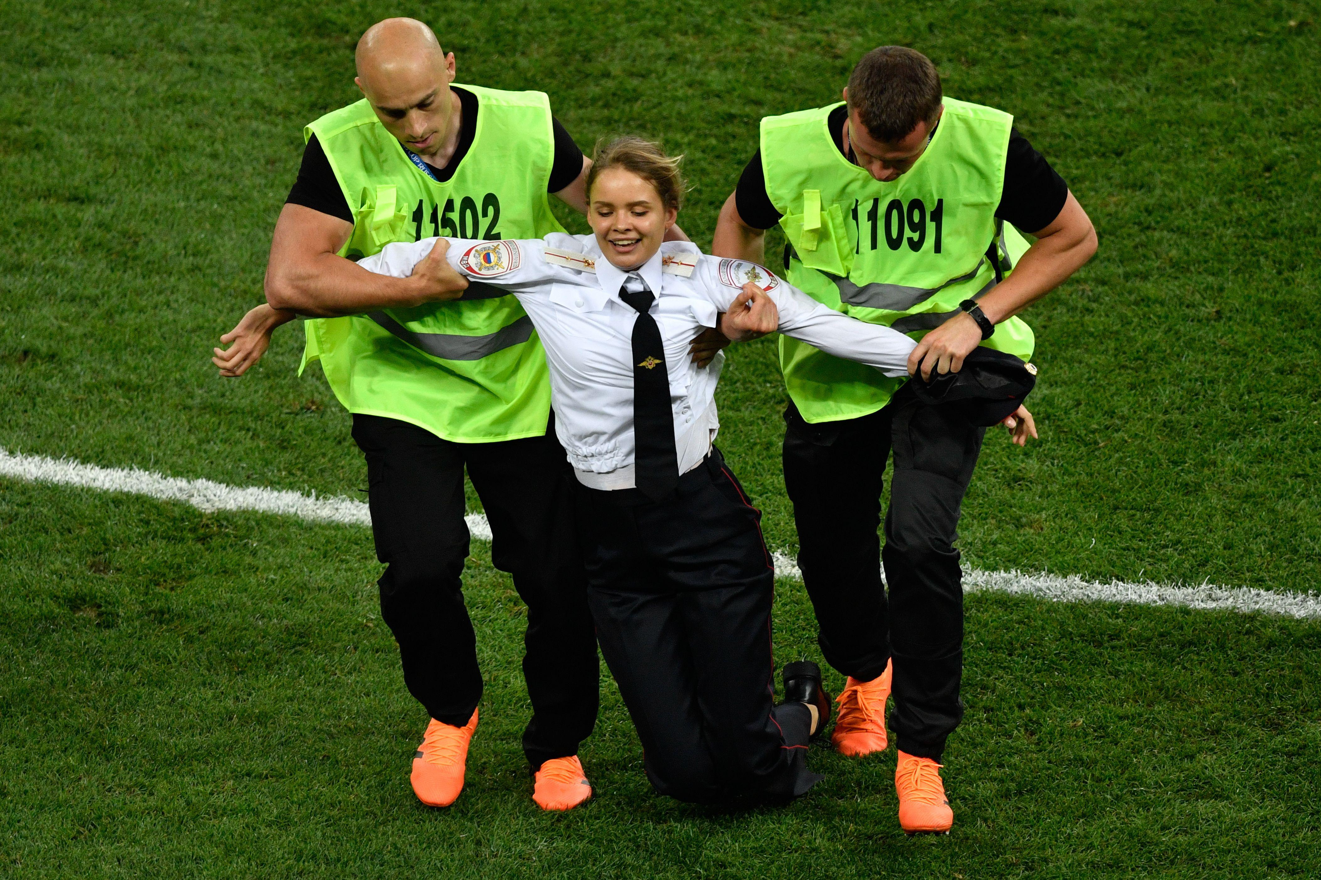 A protester is evacuated from the football pitch during the Russia 2018 World Cup final football match between France and Croatia at the Luzhniki Stadium in Moscow on July 15, 2018. 