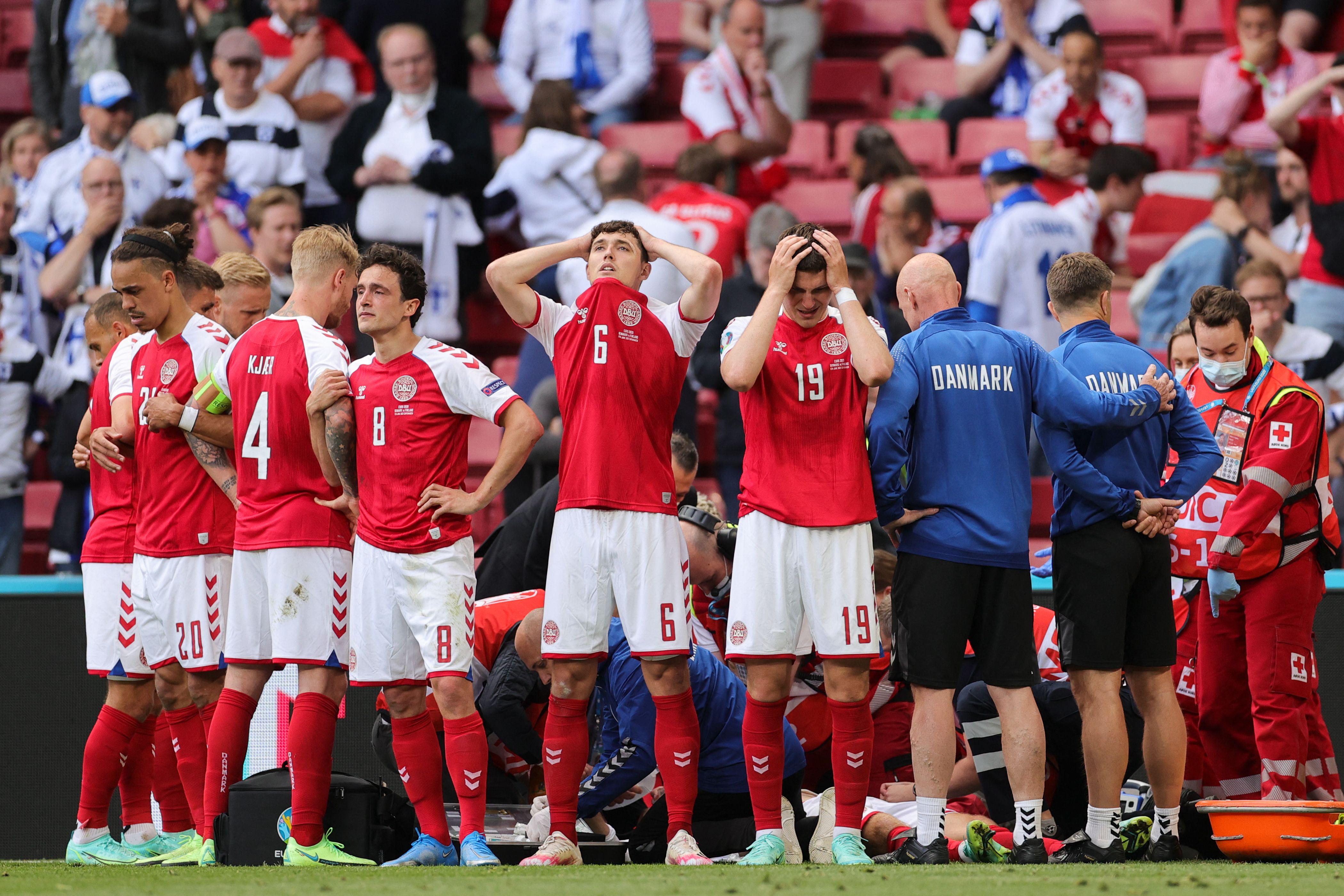 Denmark's players react as paramedics attend to Denmark's midfielder Christian Eriksen after he collapsed on the pitch during the UEFA EURO 2020 Group B football match between Denmark and Finland at the Parken Stadium in Copenhagen on June 12, 2021. 
