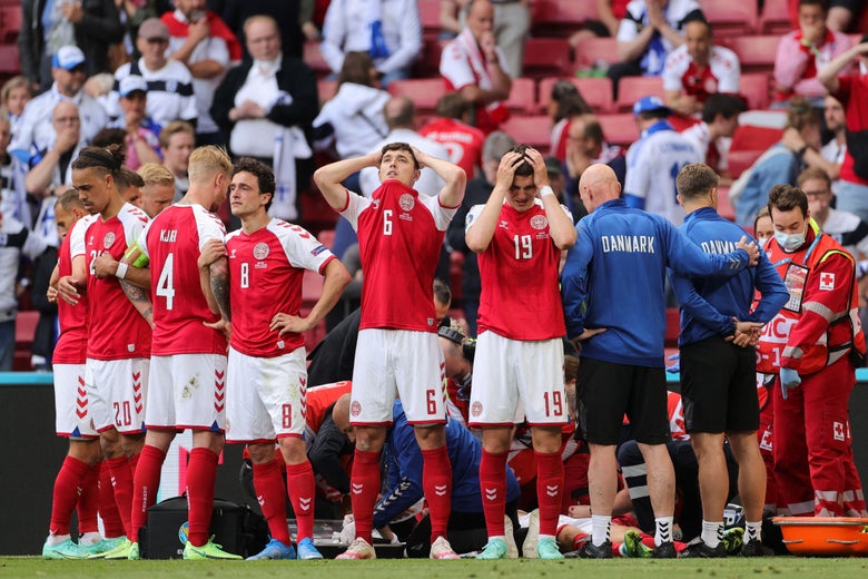 Denmark's players react as paramedics attend to Denmark's midfielder Christian Eriksen after he collapsed on the pitch during the UEFA EURO 2020 Group B football match between Denmark and Finland at the Parken Stadium in Copenhagen on June 12, 2021.