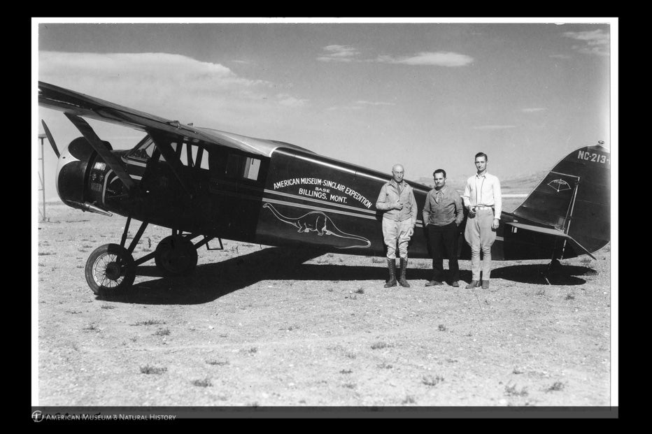 Black and white photo of three men standing in front of an airplane for the American Museum Sinclair Expedition