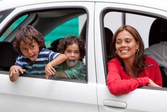 Happy woman and children in car.