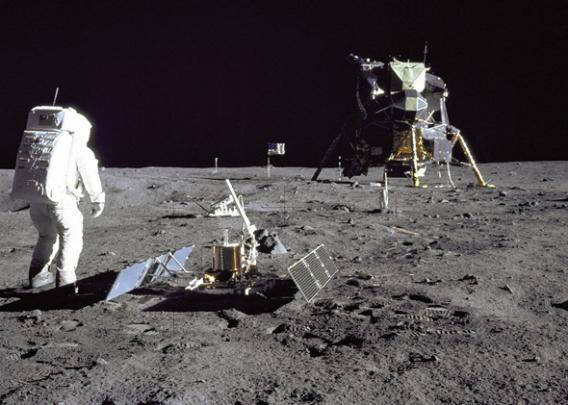 Apollo 11 astronaut Buzz Aldrin stands beside a recently deployed lunar seismometer, looking back toward the lunar landing module, 1969.