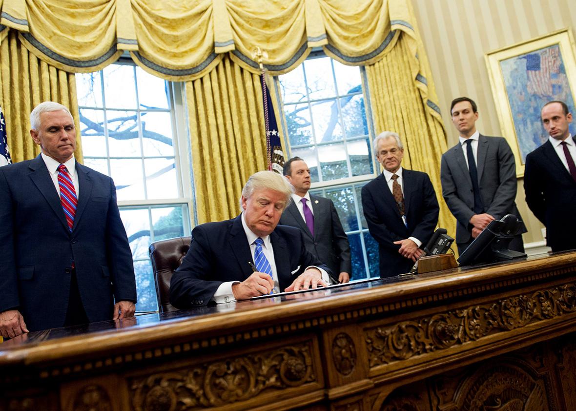 US President Donald Trump signs an executive order in the Oval Office of the White House in Washington, DC, January 23, 2017.