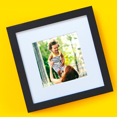 A framed photo of a woman tossing a joyous child.
