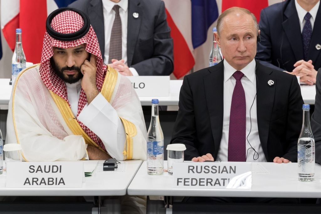 Bin Salman and Putin sit in adjacent seats amid rows of world leaders.
