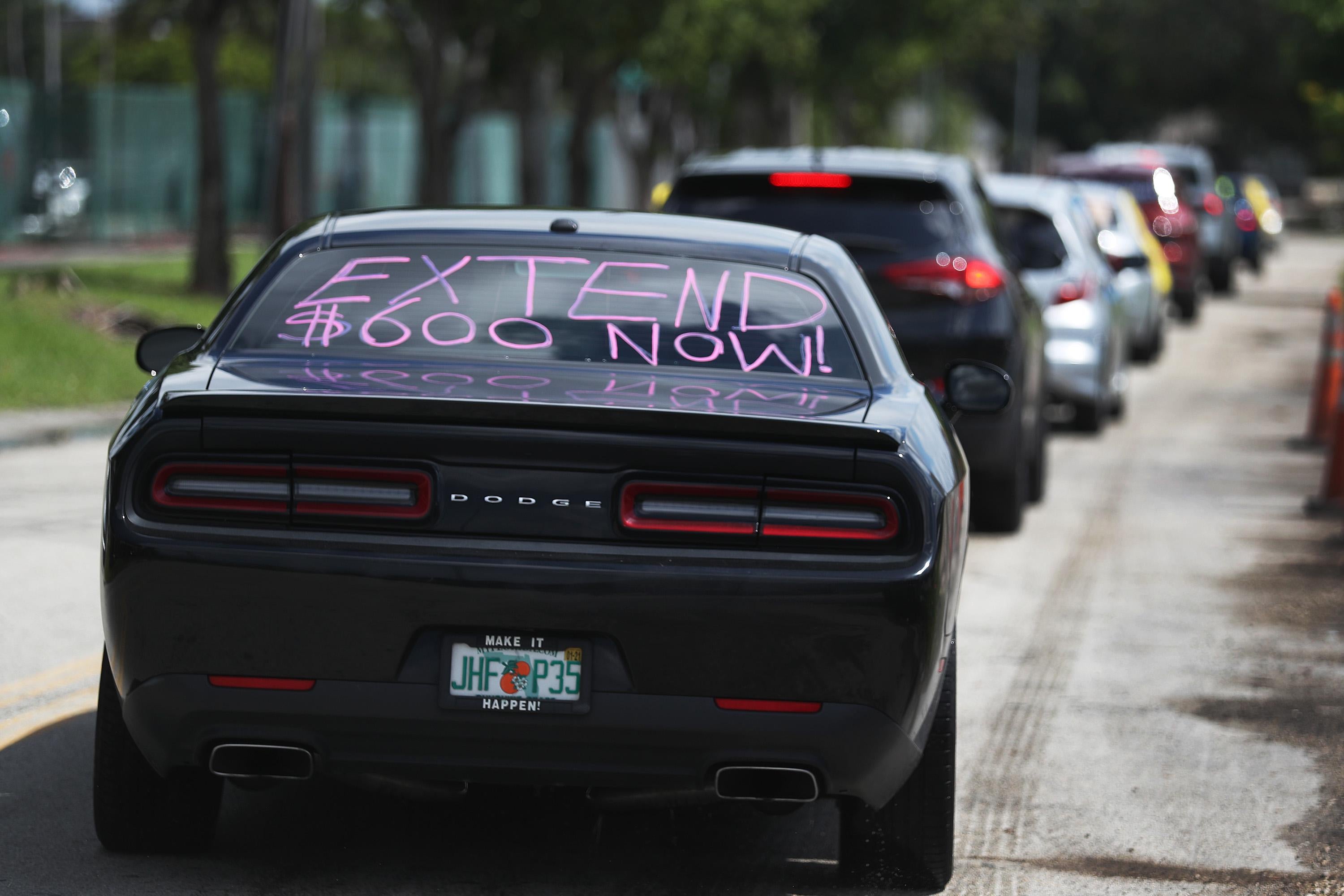 MIAMI SPRINGS, FLORIDA - JULY 16: A car with, ' extend $600 now!', written on the rear window participates in a caravan protest on July 16, 2020 in Miami Springs, Florida.  The caravan was driving to the Coral Gables office of Sen. Rick Scott to ask him and other Senators to support the new Schumer/Wyden legislation that extends unemployment benefits for all laid-off Americans as the coronavirus pandemic continues to disrupt the economy.  (Photo by Joe Raedle/Getty Images)