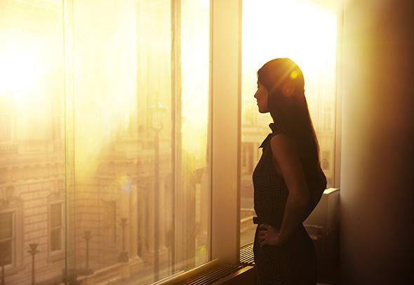 Business woman looking over the city at sunrise.