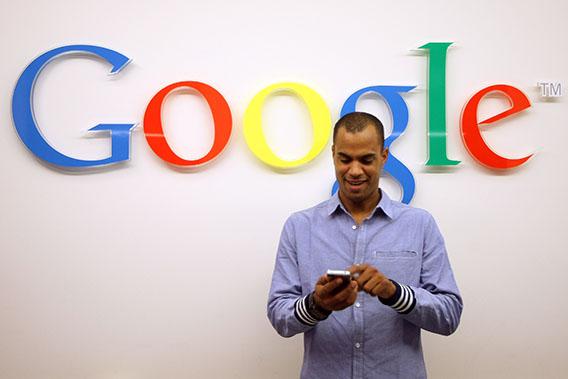 A visitor uses a cell phone in front of the Google logo on September 26, 2012 at the official opening party of the Google offices in Berlin, Germany.