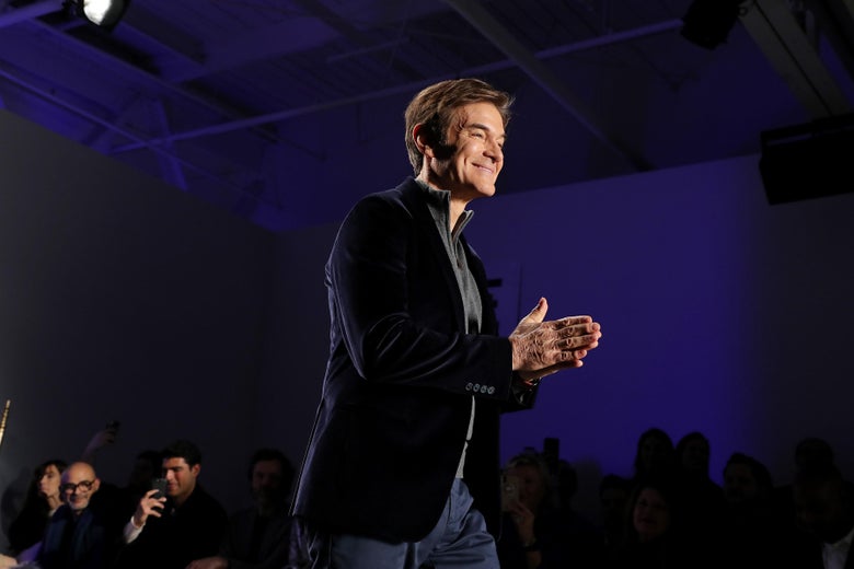 Dr. Oz folds his hands while speaking to an audience.