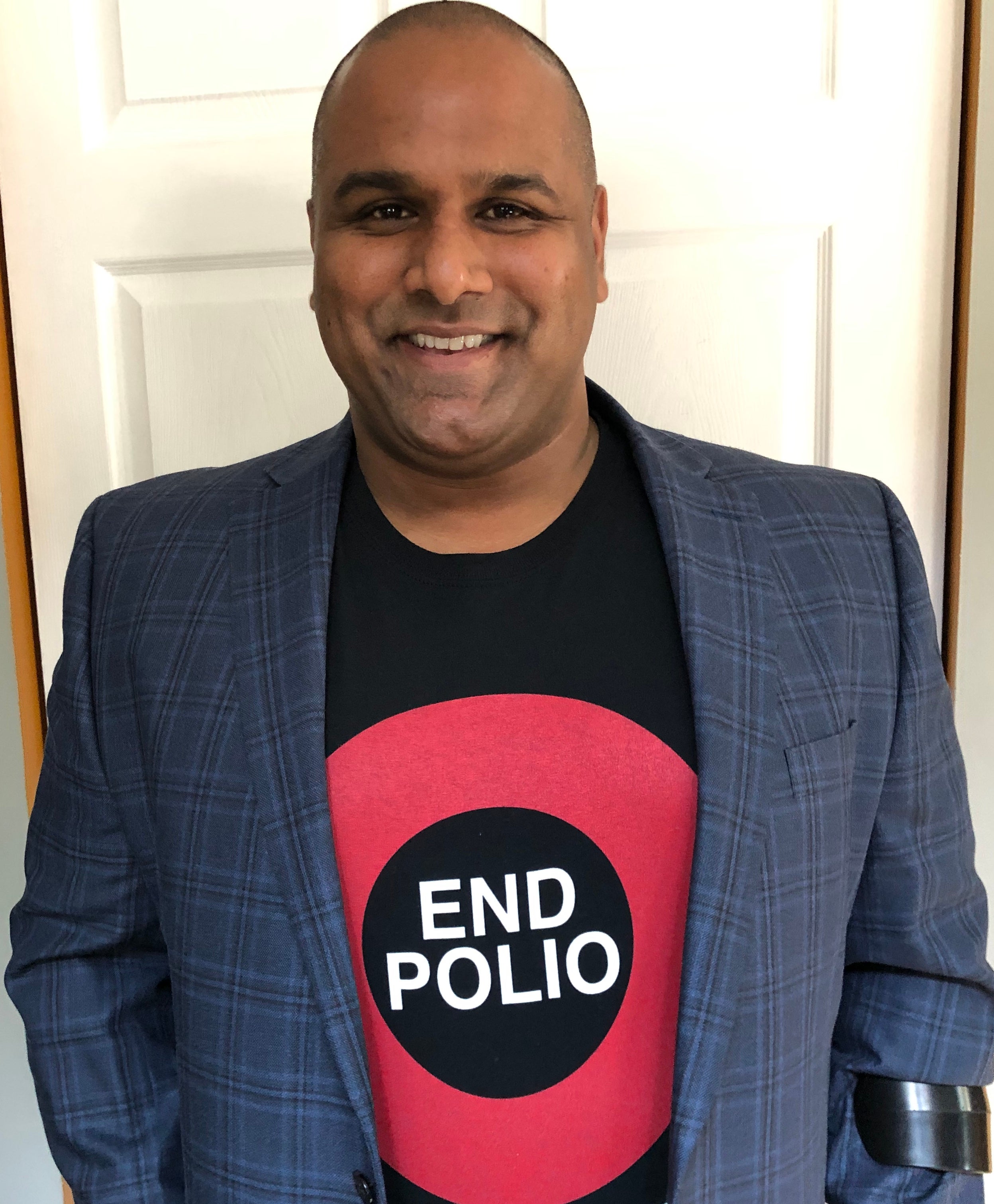 A picture of Ramesh Ferris wearing a shirt that says end polio

