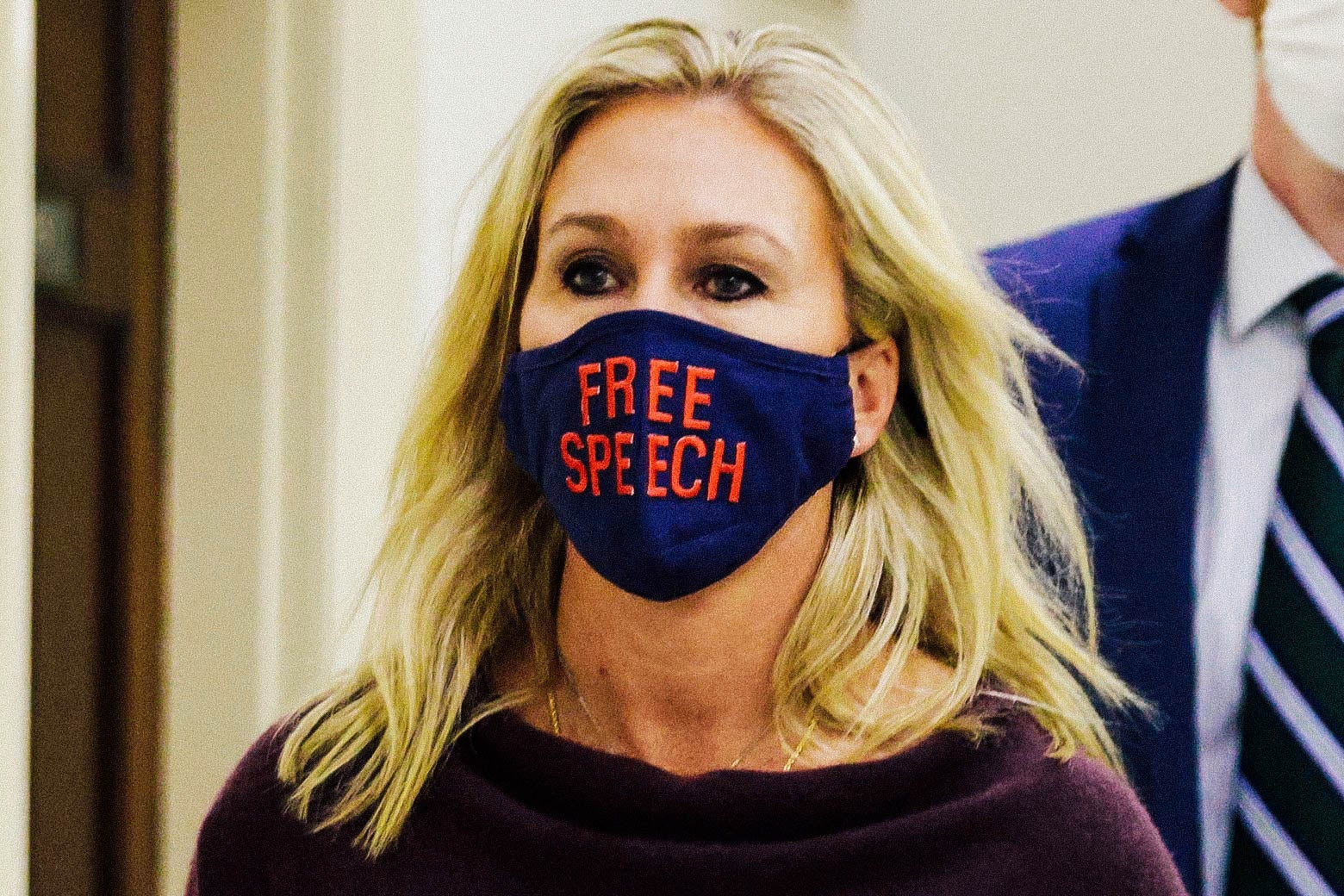 Marjorie Taylor Greene wears a face mask that reads "Free Speech."