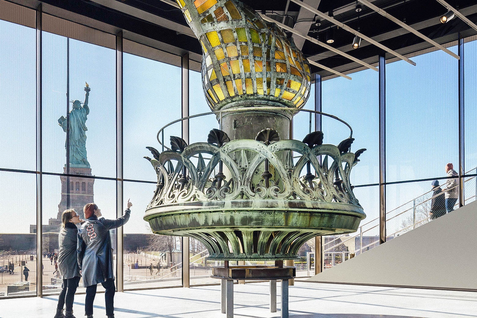 Inside the museum, visitors look at the original torch.