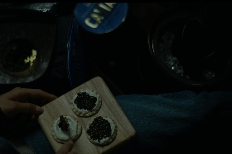 Caviar-topped crackers on a serving board