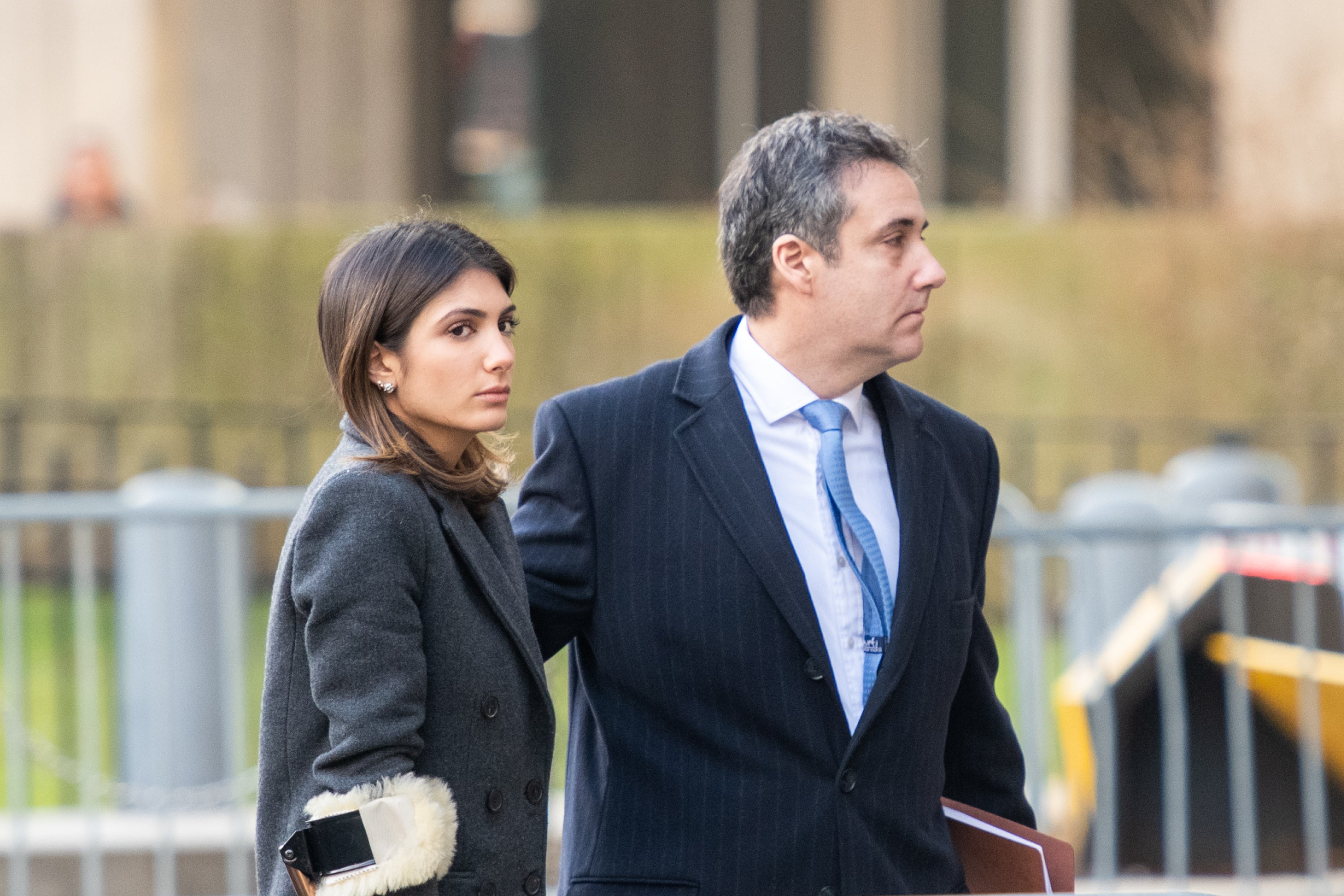 Samantha Cohen and her father Michael Cohen are outdoors near sidewalk barricades.