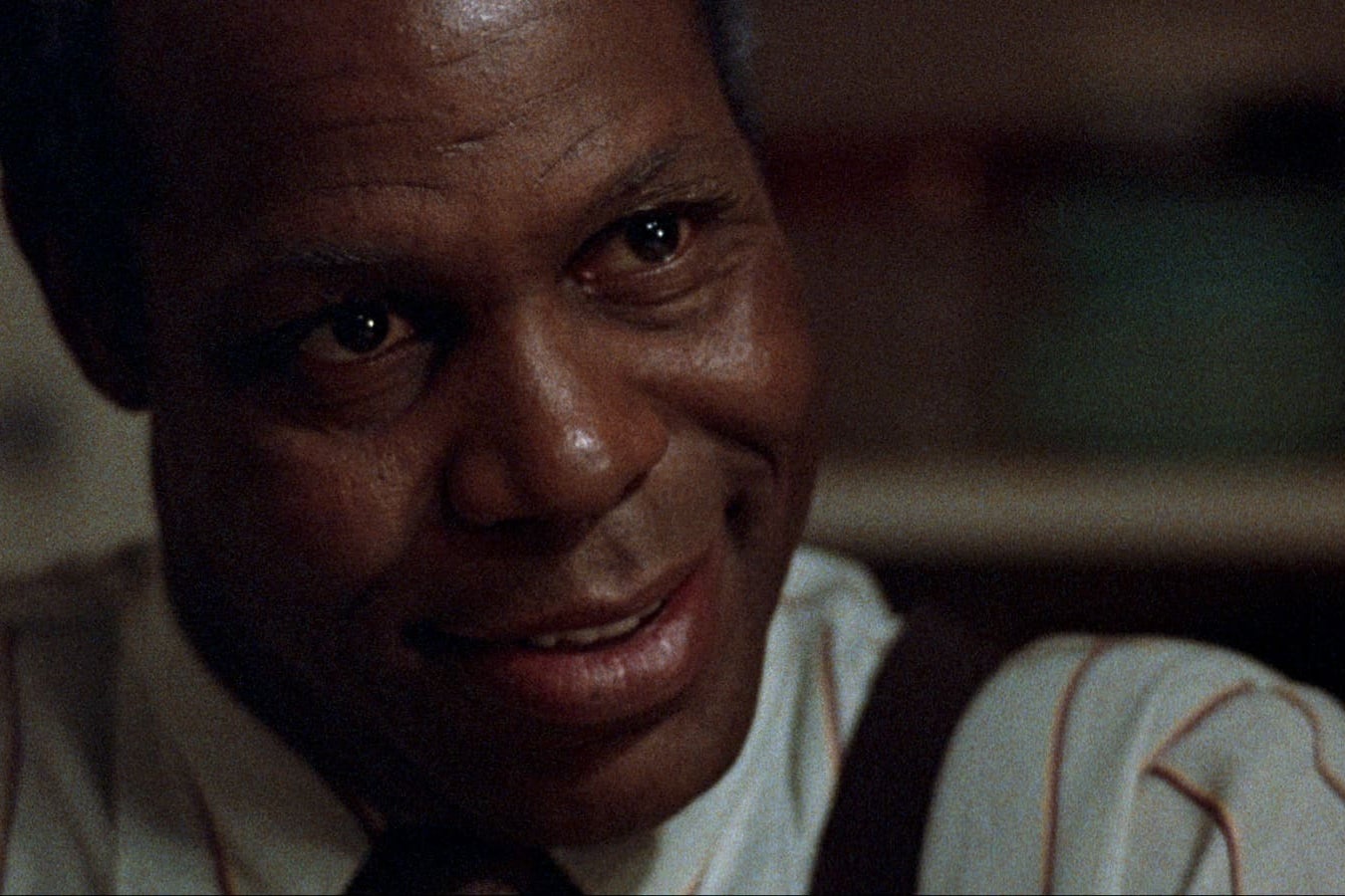Close up of Danny Glover smiling.