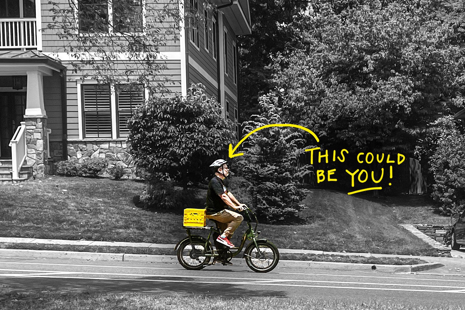 Dan Kois zips up a hill on an e-bike with an orange milk crate on the back.