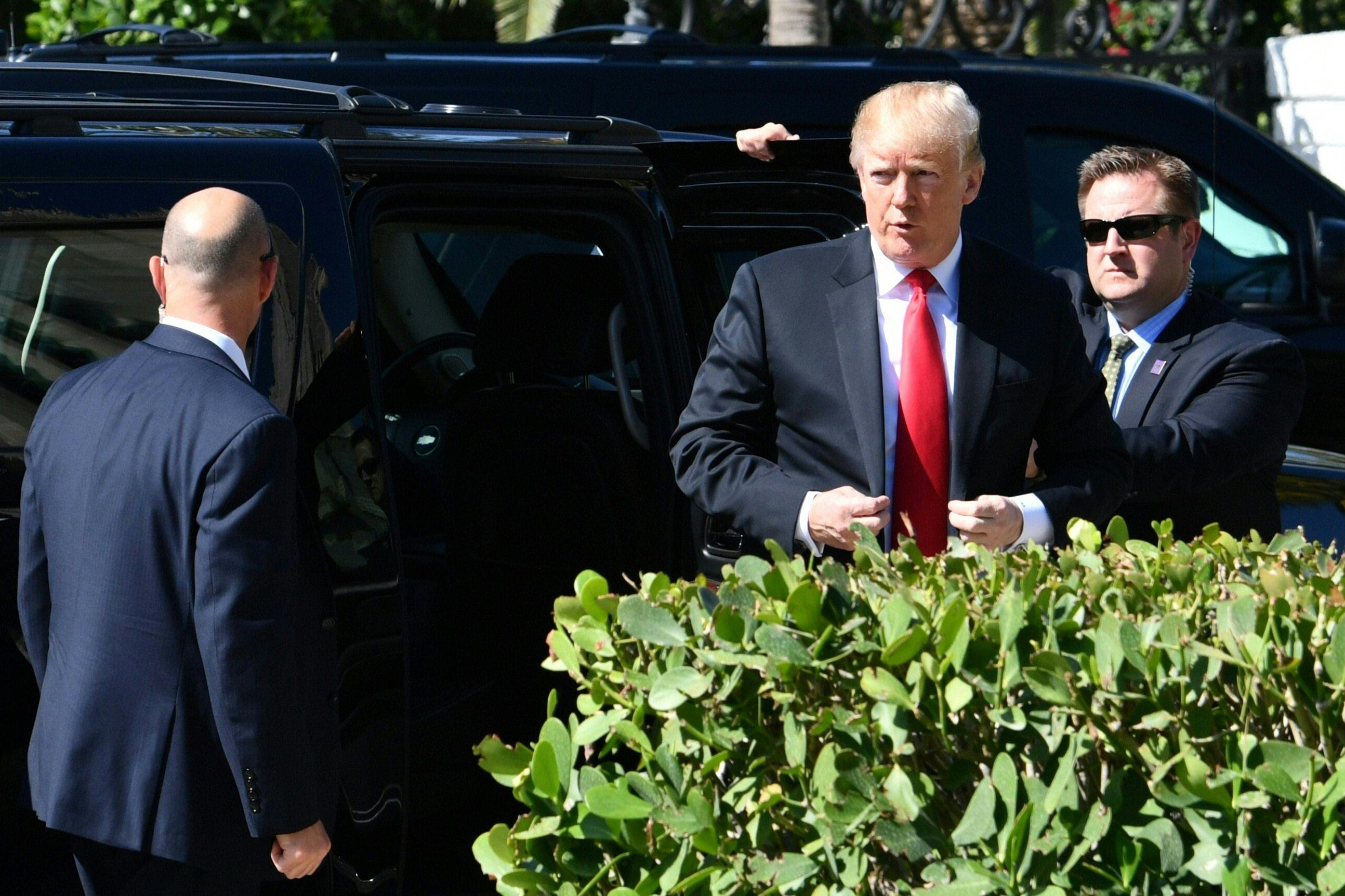 President Trump emerges from a black SUV.