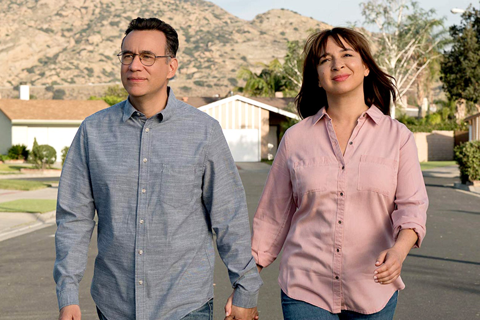 Fred Armisen and Maya Rudolph stroll down a street a still from Forever. 