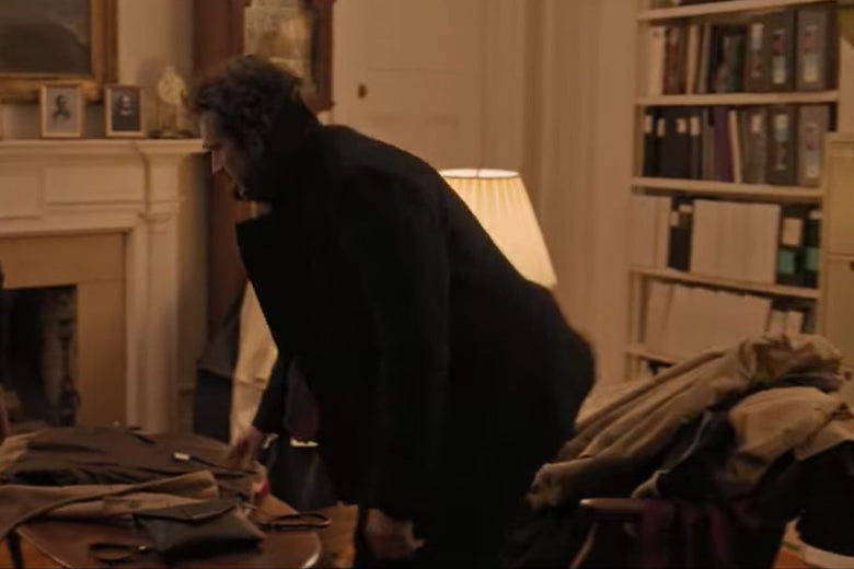 Bill standing in front of a chair covered in coats.