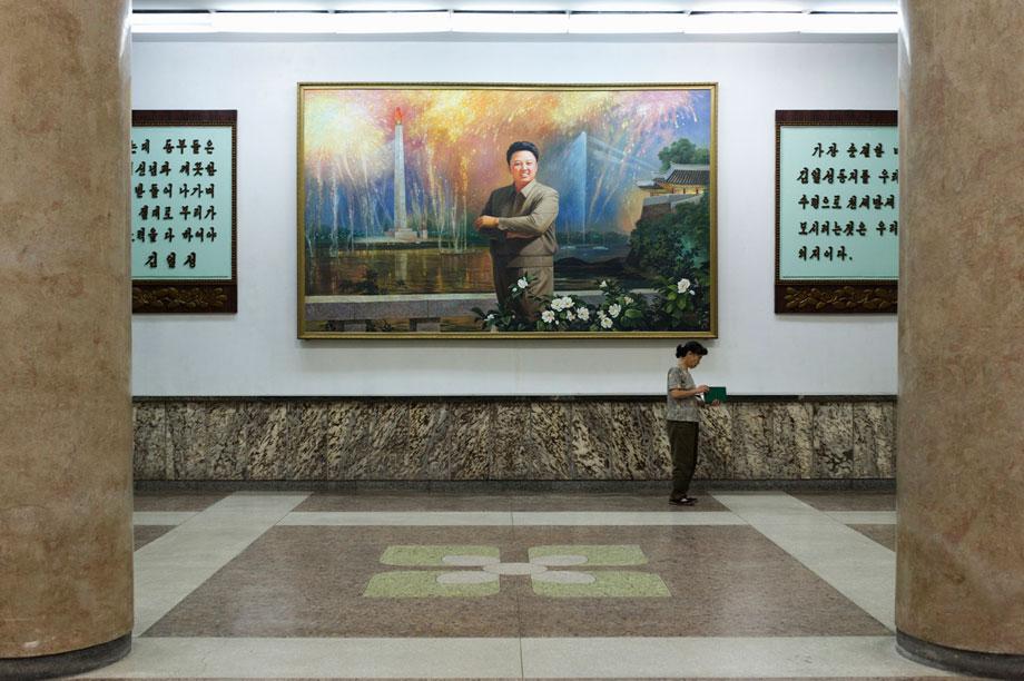 Woman reading a book under a Kim Jong-il painting Grand People's Study House, North Koreas biggest library and educational centre.  It has a total floor space of 100,000m2 and 600 rooms. Foreign publications are available only with special permission.