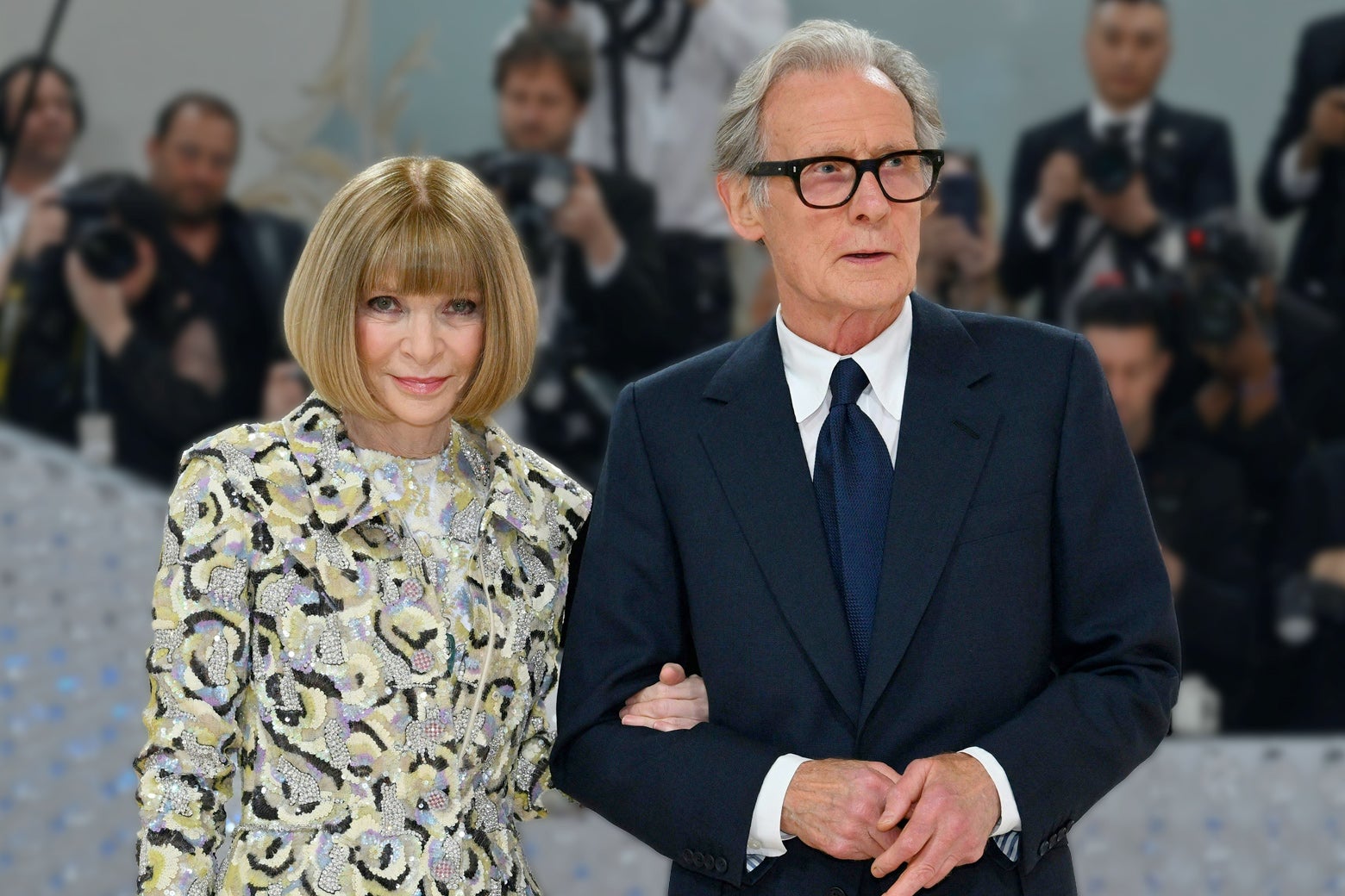 Anna Wintour stands beside Bill Nighy in formal wear.