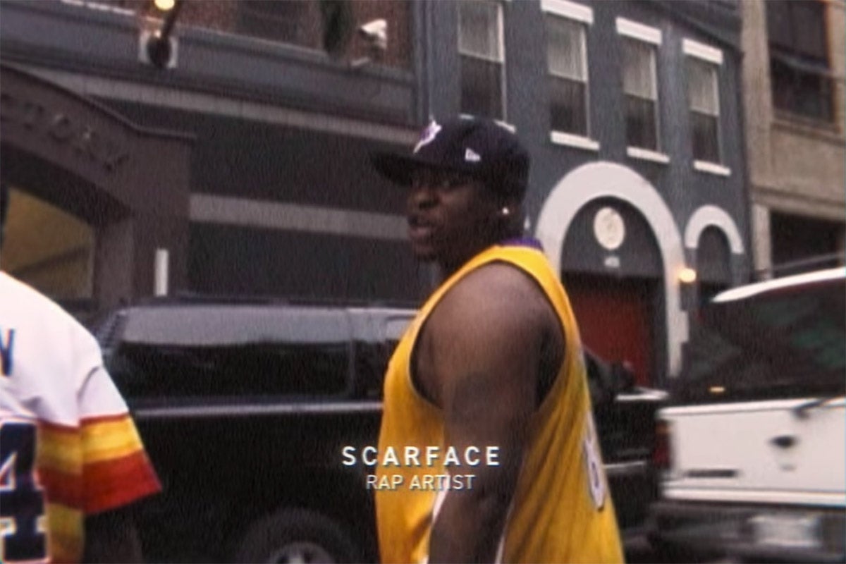 Scarface in a basketball jersey and cap.