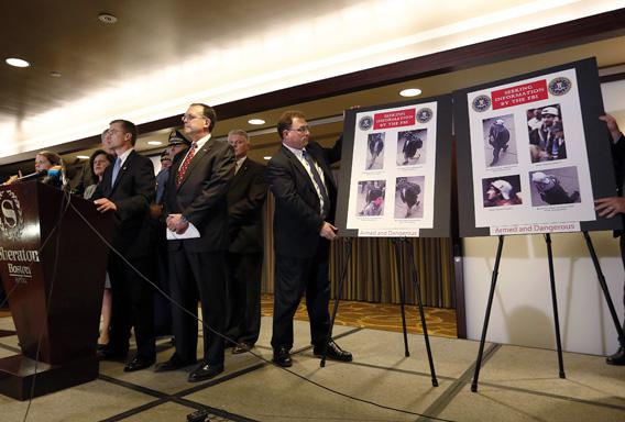 Boston FBI Special Agent in Charge Richard DesLauriers (L) speaks as photos of suspects in the Boston Marathon bombings.