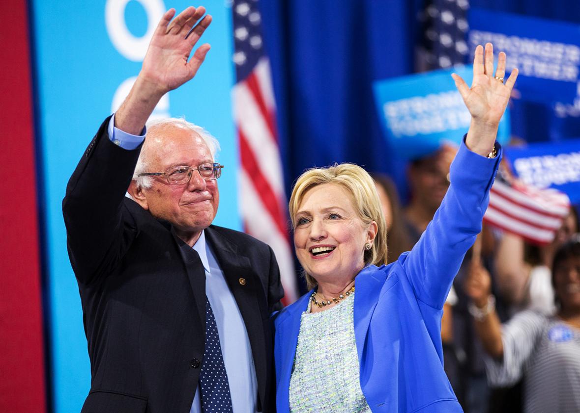 Presumptive Democratic presidential candidate Hillary Clinton and Bernie Sanders waves after speaking at a rally in Portsmouth, New Hampshire on July 12, 2016 where she received Sanders' endorsement. 