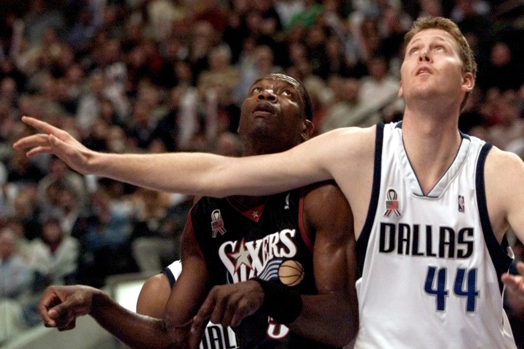 Philadelphia 76ers center Dikembe Mutombo and Dallas Mavericks center Shawn Bradley battle for position under the basket during a 2001 NBA game