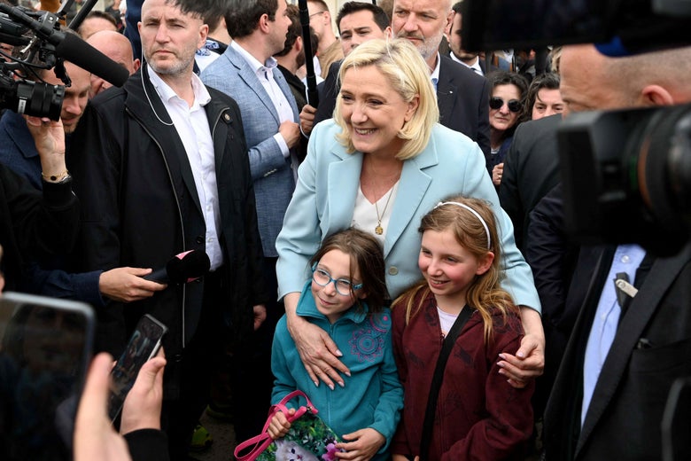 French far-right party Rassemblement National (RN) presidential candidate Marine Le Pen poses for a picture with two girls during her visit in the coastal city of Berck as part of a one-day campaign visit in northern France on April 22, 2022, two days ahead of the second round of the French presidential election. (Photo by DENIS CHARLET / AFP) (Photo by DENIS CHARLET/AFP via Getty Images)