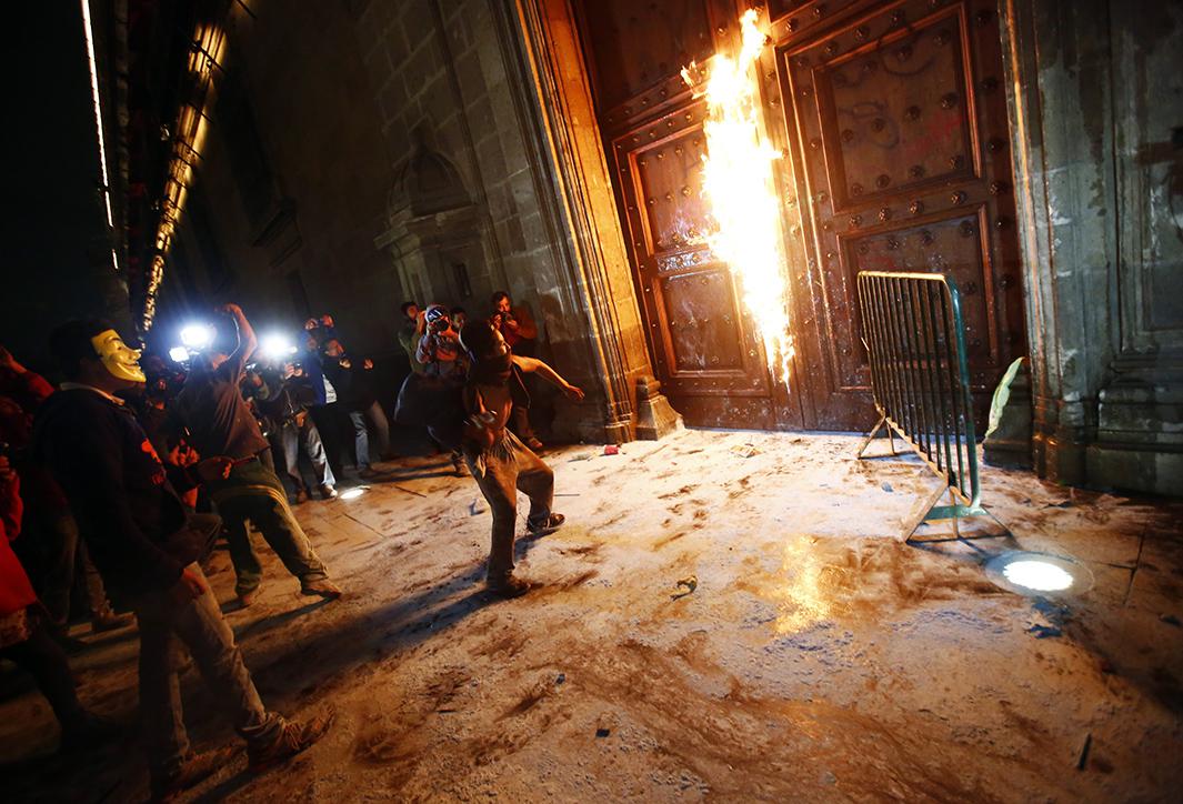 A group of protesters set fire to presidential palace’s wooden door on Nov. 8.