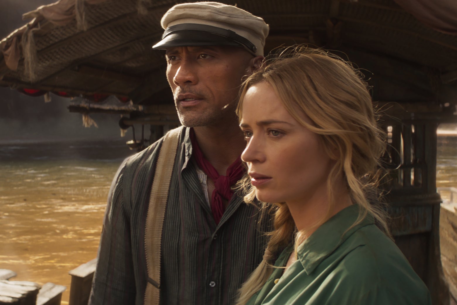 Dwayne The Rock Johnson and Emily Blunt stand on a boat in a still from Jungle Cruise.