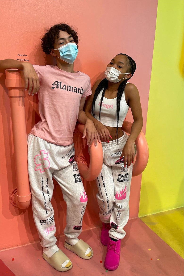The two teenagers pose for a photo wearing face masks and matching sweatpants.