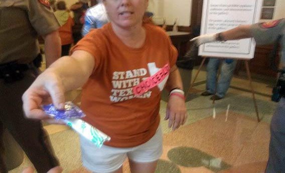 A woman handing a tampon and condom that were not allowed in Texas Senate gallery.