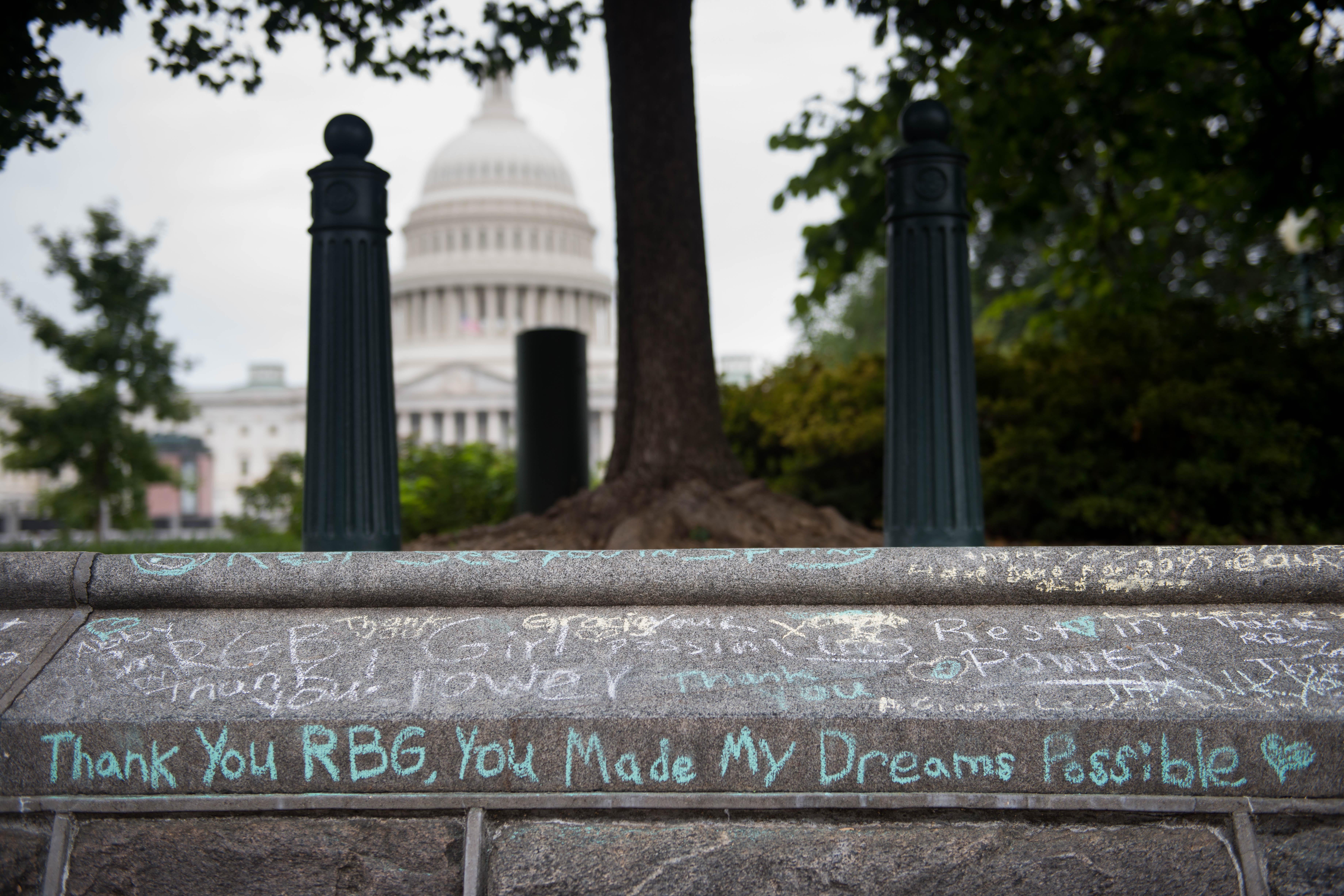 Chalk inscriptions to RBG, including "Thank you RBG, you made my dreams possible" are seen on a wall near the Capitol.